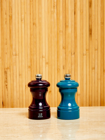 One eggplant and one blue Salt and Pepper Mill by Peugeot.