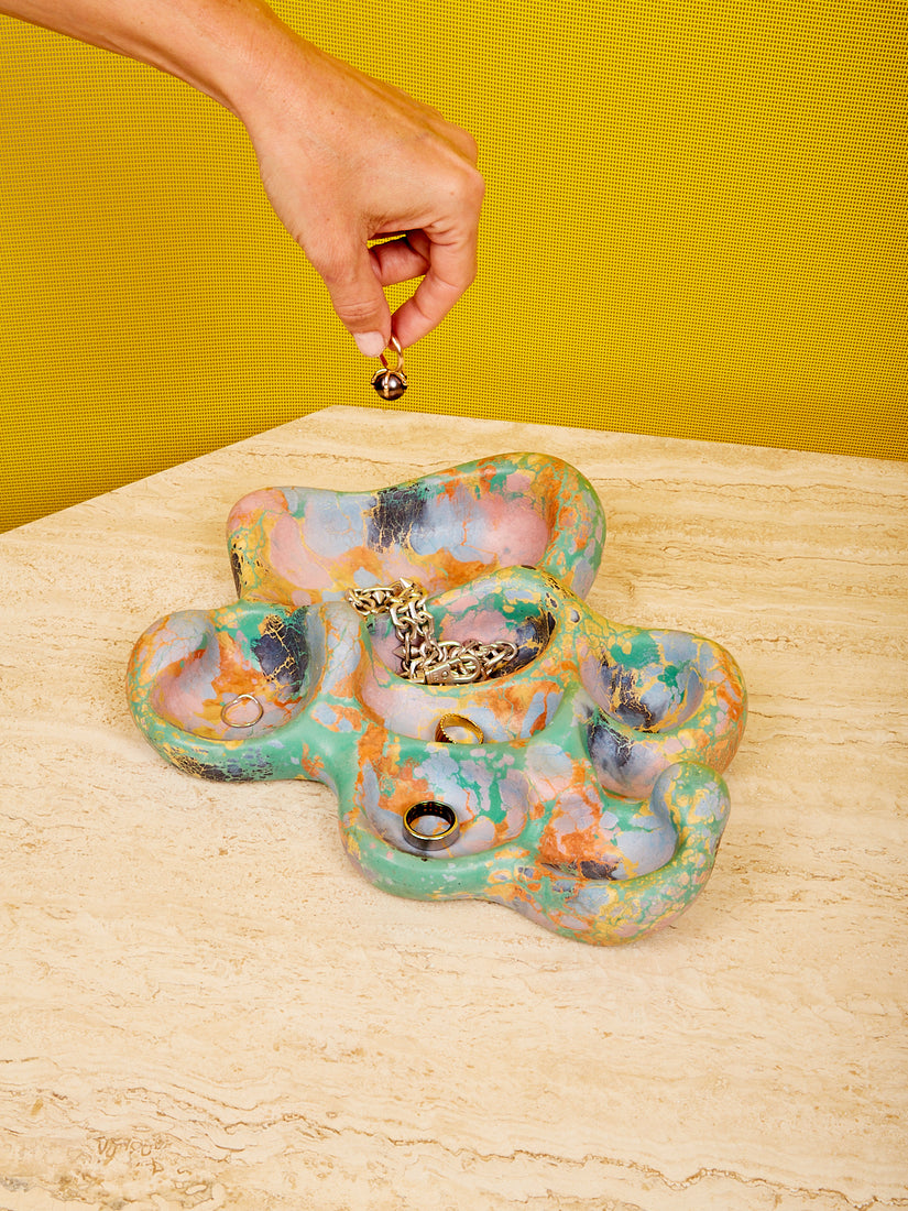 The Aphrodite Trinket Tray by Concrete Cat in the green and orange colorway full of jewelry.