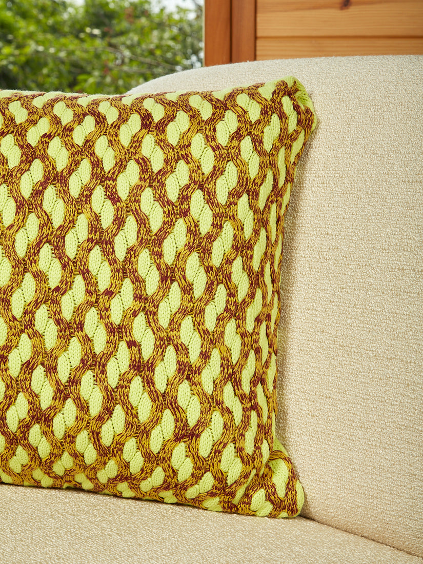 A close up of the lime colorway squiggle cable pillow.