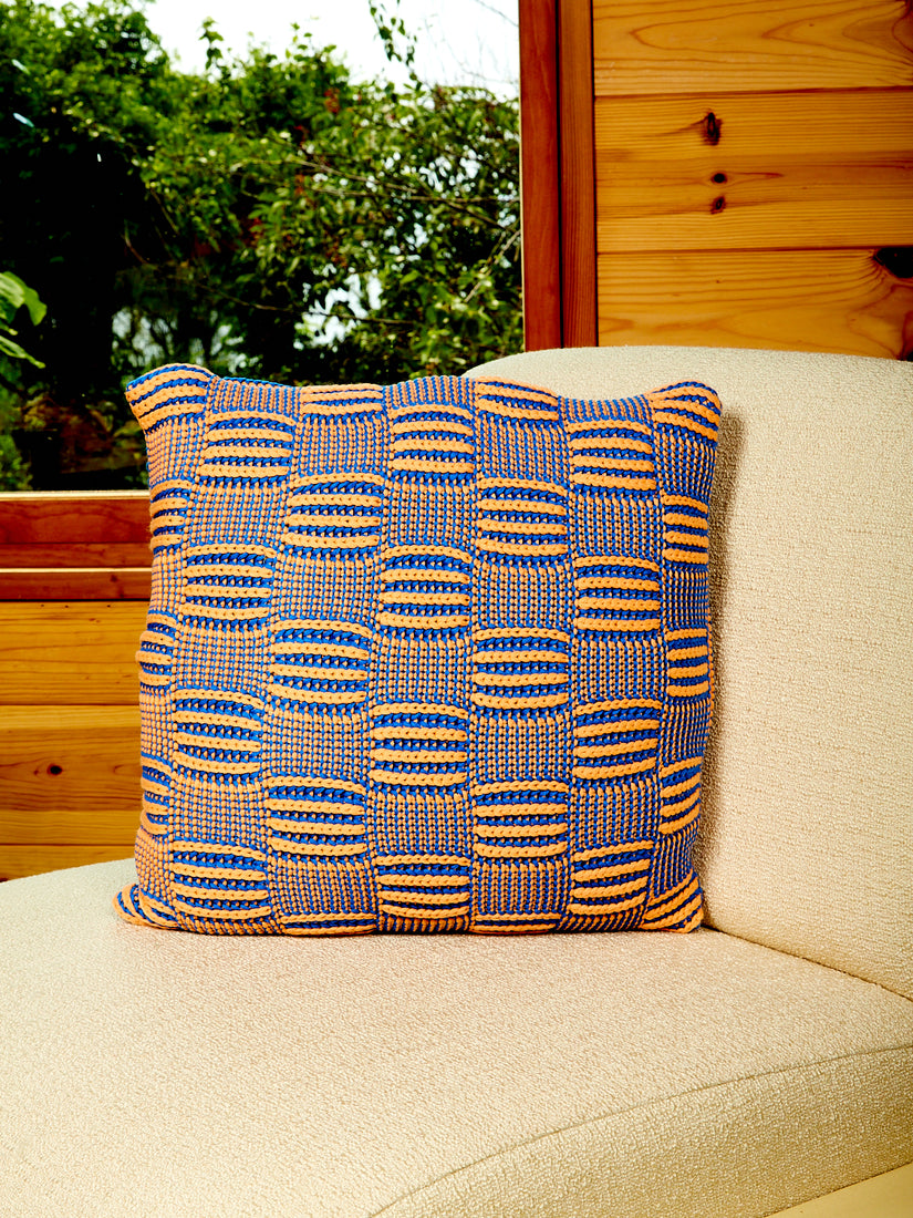 A Chunky Checkerboard Pillow by Verloop in cobalt blue and salmon orange.