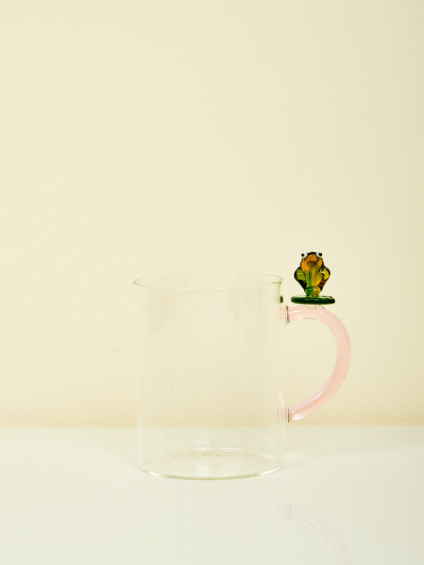 The Animal Farm Mug by Ichendorf Milano in the frog style. A green frog sits at the top of a pink glass handle.