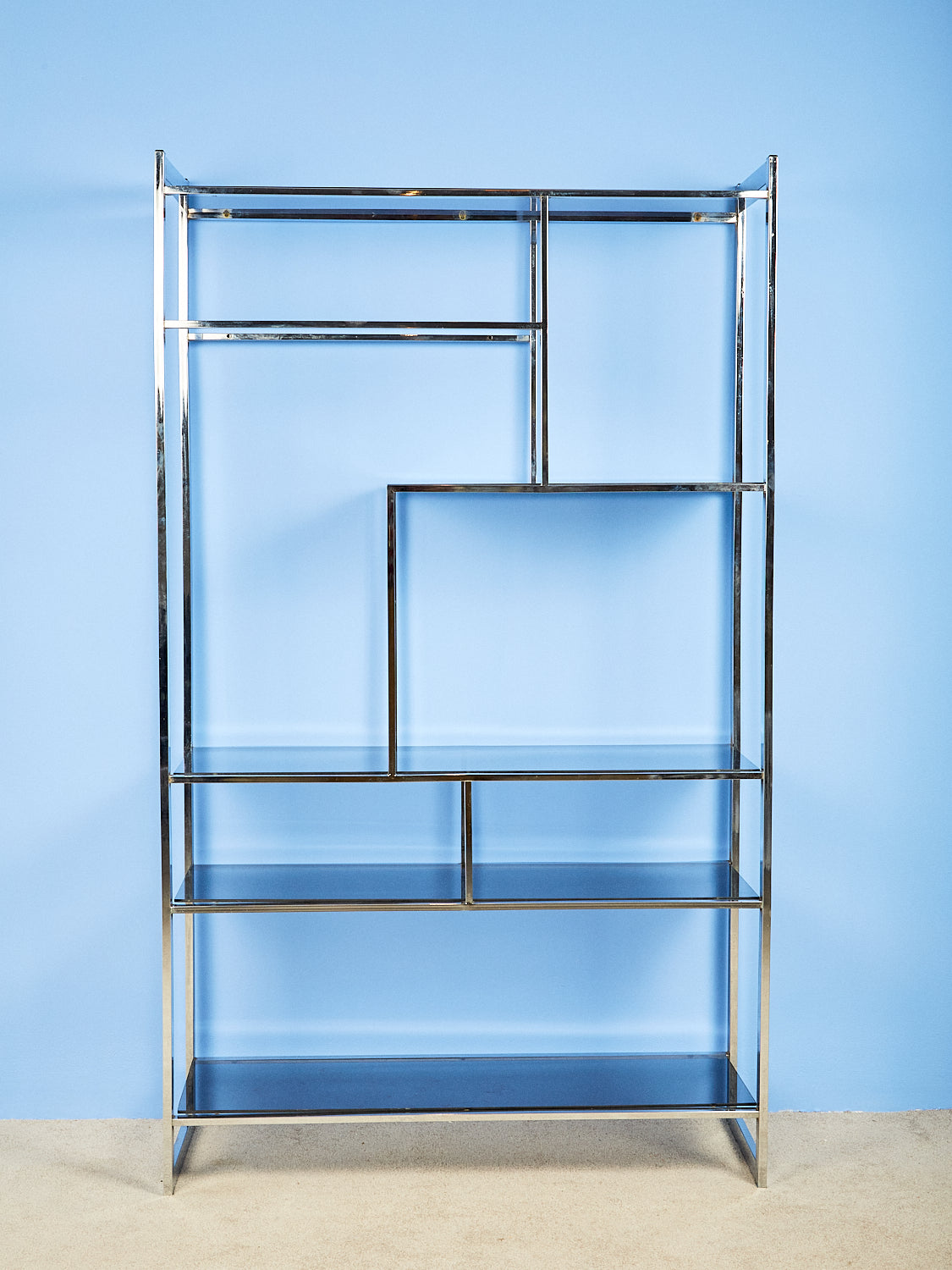 Chromea nd Smoke Glass Etagere against a blue wall.