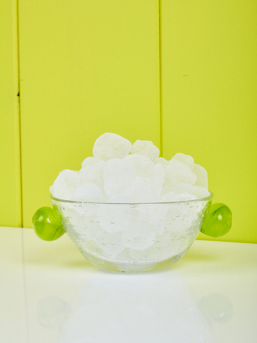 A Clear/Green Glass Bubble Bowl by La Romaine Editions full of ice cubes.