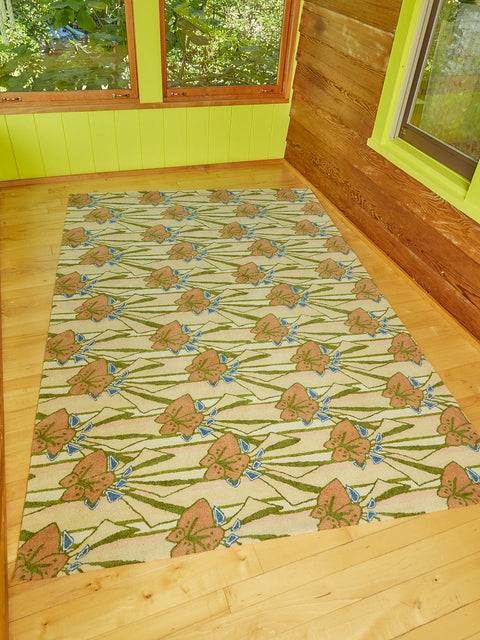 Freckle Flower Rug by Cold Picnic in a bright green sun room with the sun shining on the floor and rug.