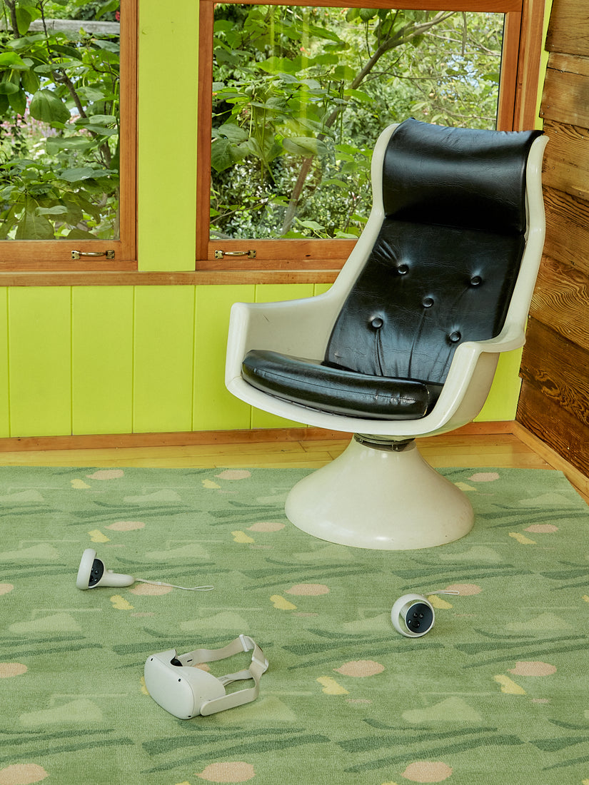A vintage 1970s Space Age white and black armchair and an Oculus game set sit atop a Sweetie Rug.