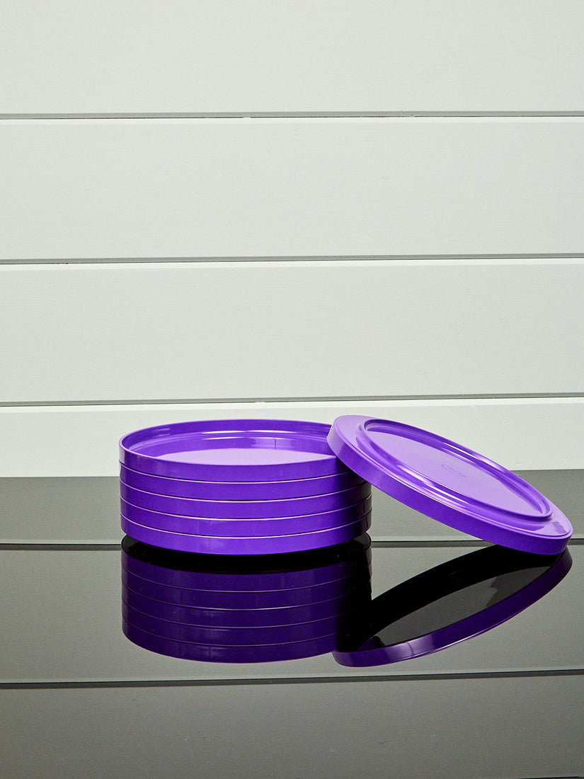 A stack of purple dinner plates by Heller with one laying and leaning upside down.