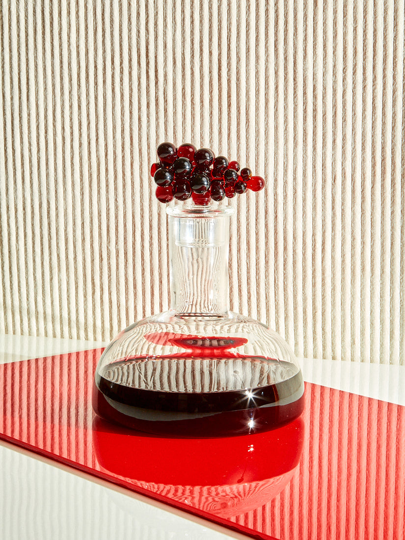 The Bordeaux Wine Decanter by Maison Balzac with a wine colored glass bunch of grapes on the stopper.