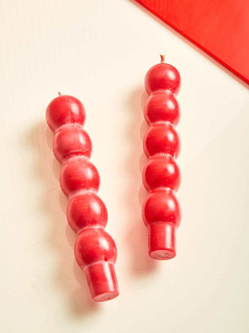 A pair of red volute candles by Maison Balzac.