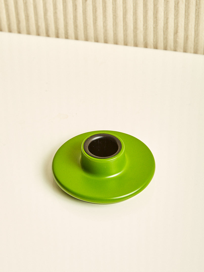 A green saucer shaped candle holder. 