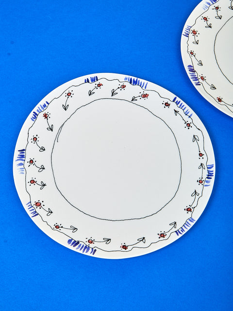 Birds eye view of the plate by Marni showing the details on the edge of the plate. The details include delicate colorings of flowers. 