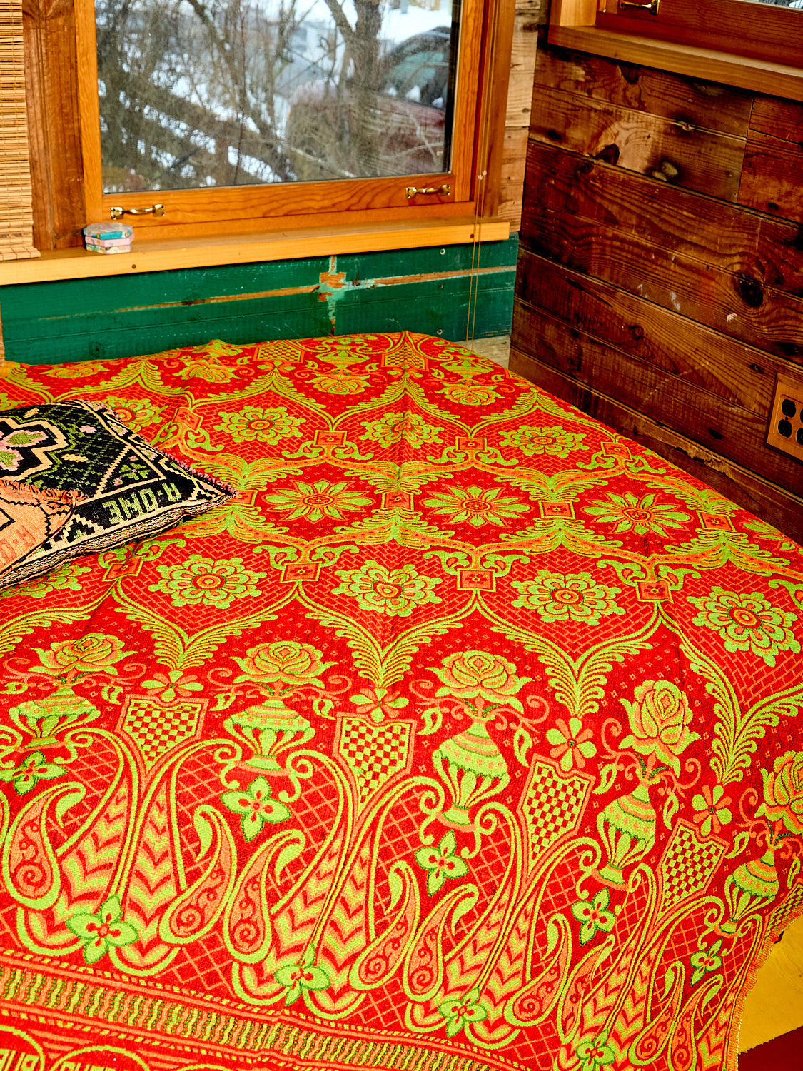 Zoom in picture of the Reversible Blanket/Rug on the bed. This picture shows the red color of the blanket/rug.