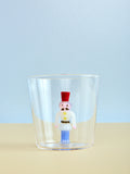 Clear glass with a decorative nutcracker figure inside on a light blue background