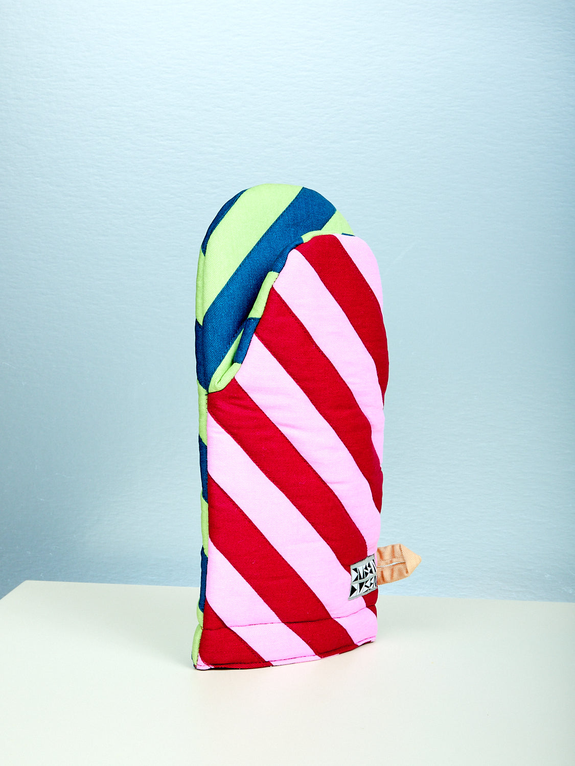 Colorful striped oven mitt on a light blue background
