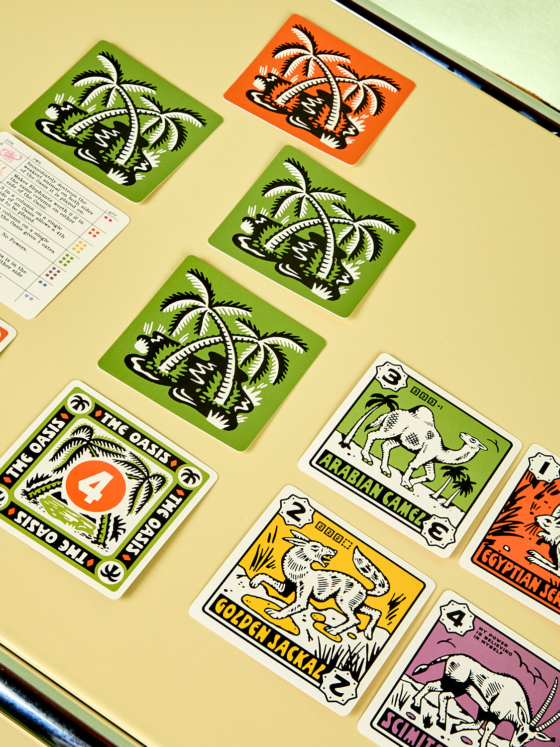 Collection of vintage-style playing cards with animal illustrations on a beige surface.