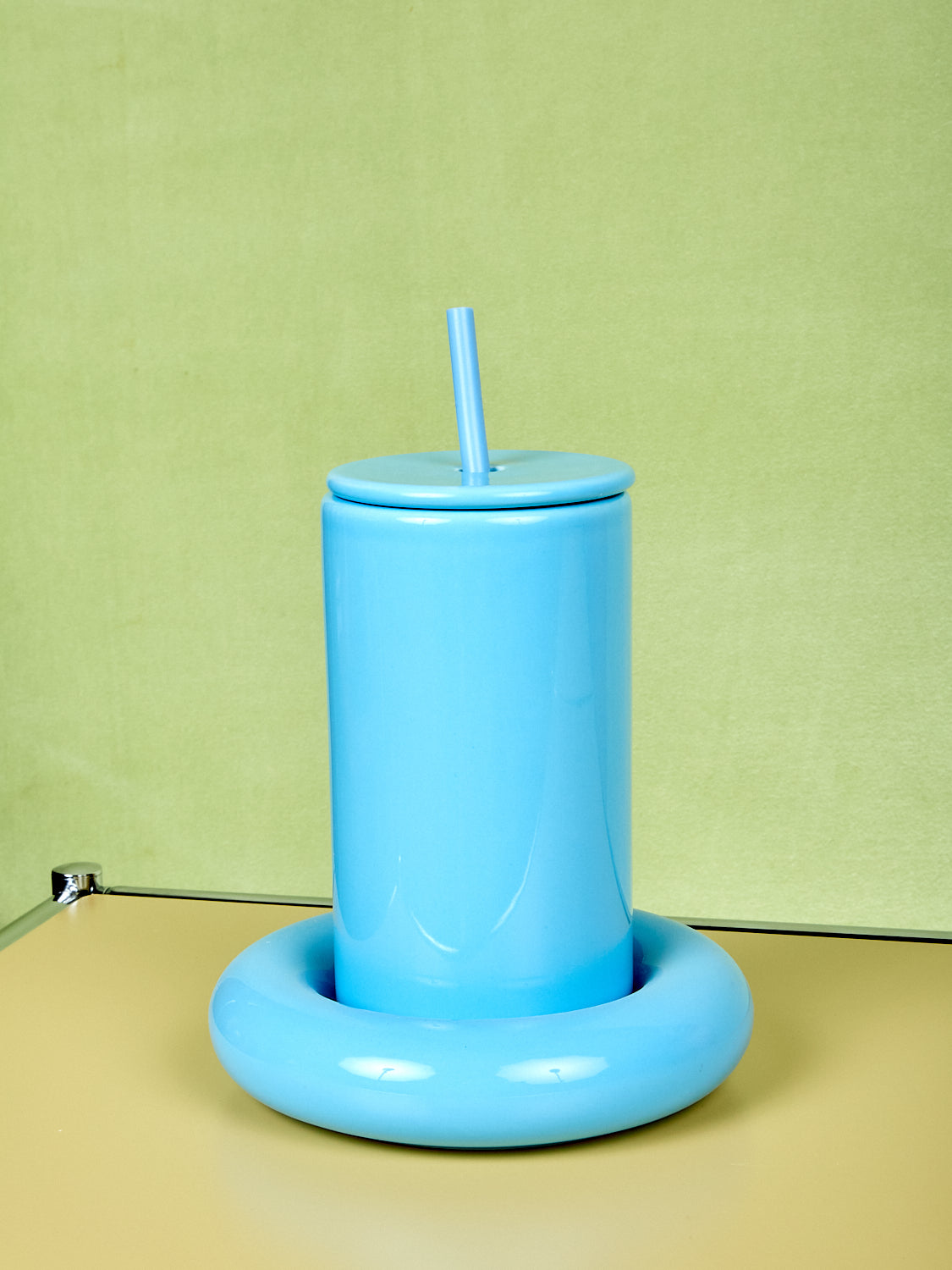 Blue Gustaf Westman tumbler with a straw