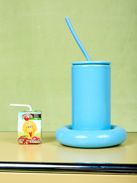 Blue Gustaf Westman tumbler with a straw