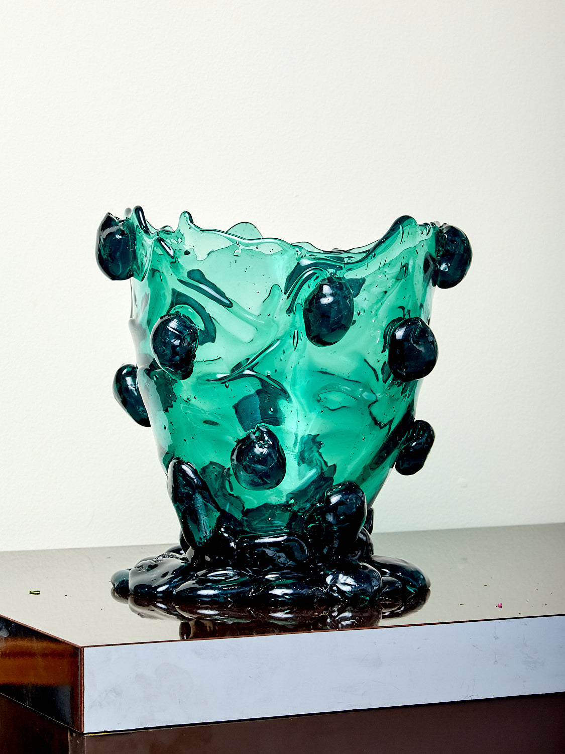 Green resin vase with black accents on a white background
