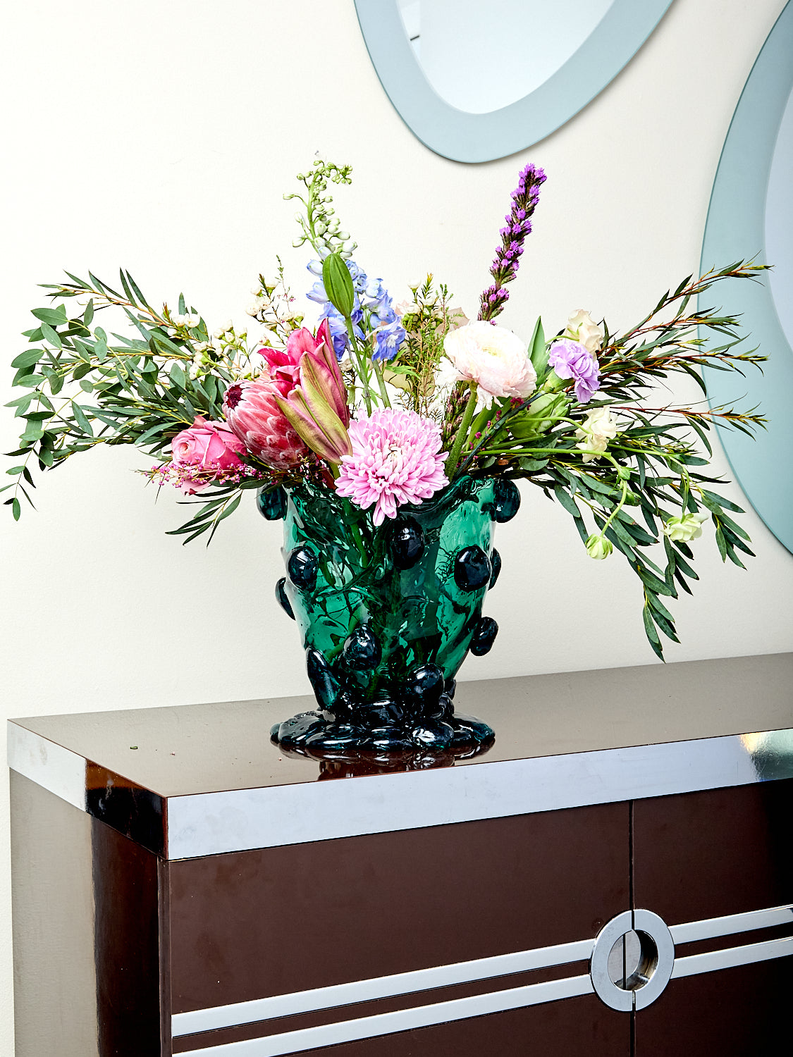 Decorative vase with flowers on a wooden surface