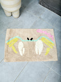 Beige bathmat with ivory, yellow, sky blue, and pink 'Cancer' design on a tiled floor