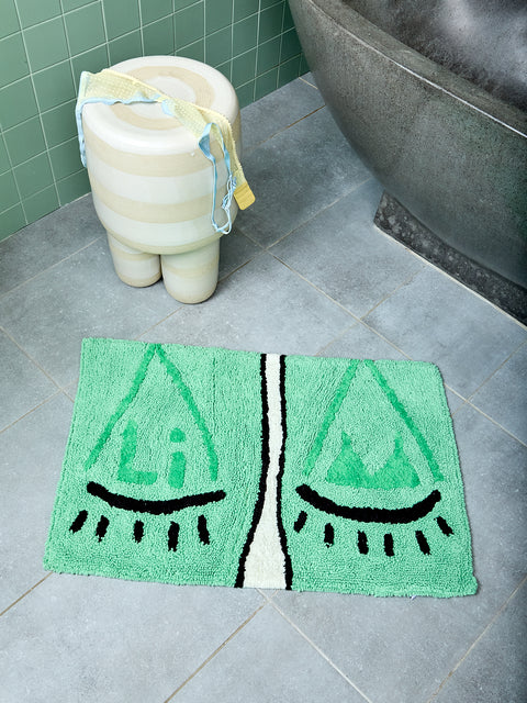 Bathmat with 'Libra' design on a tiled floor