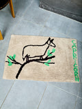 Bathmat with a deer design and text reading "CAPRICORN" on a tiled floor 