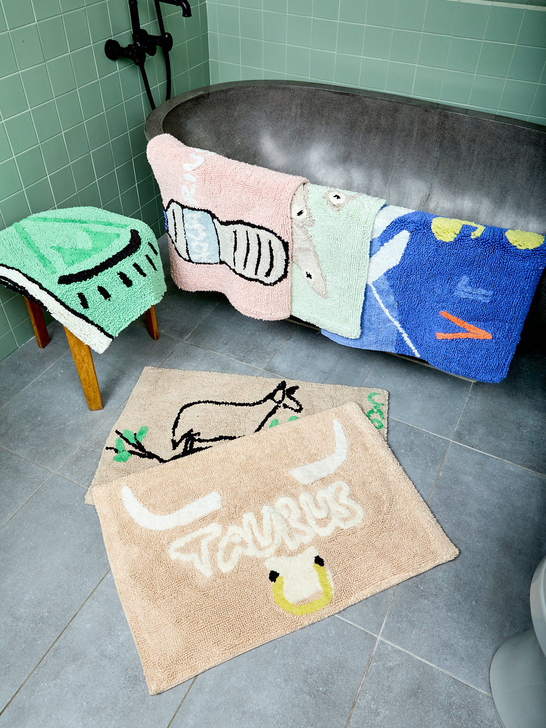 Assorted bathmats on a bathroom floor and tub