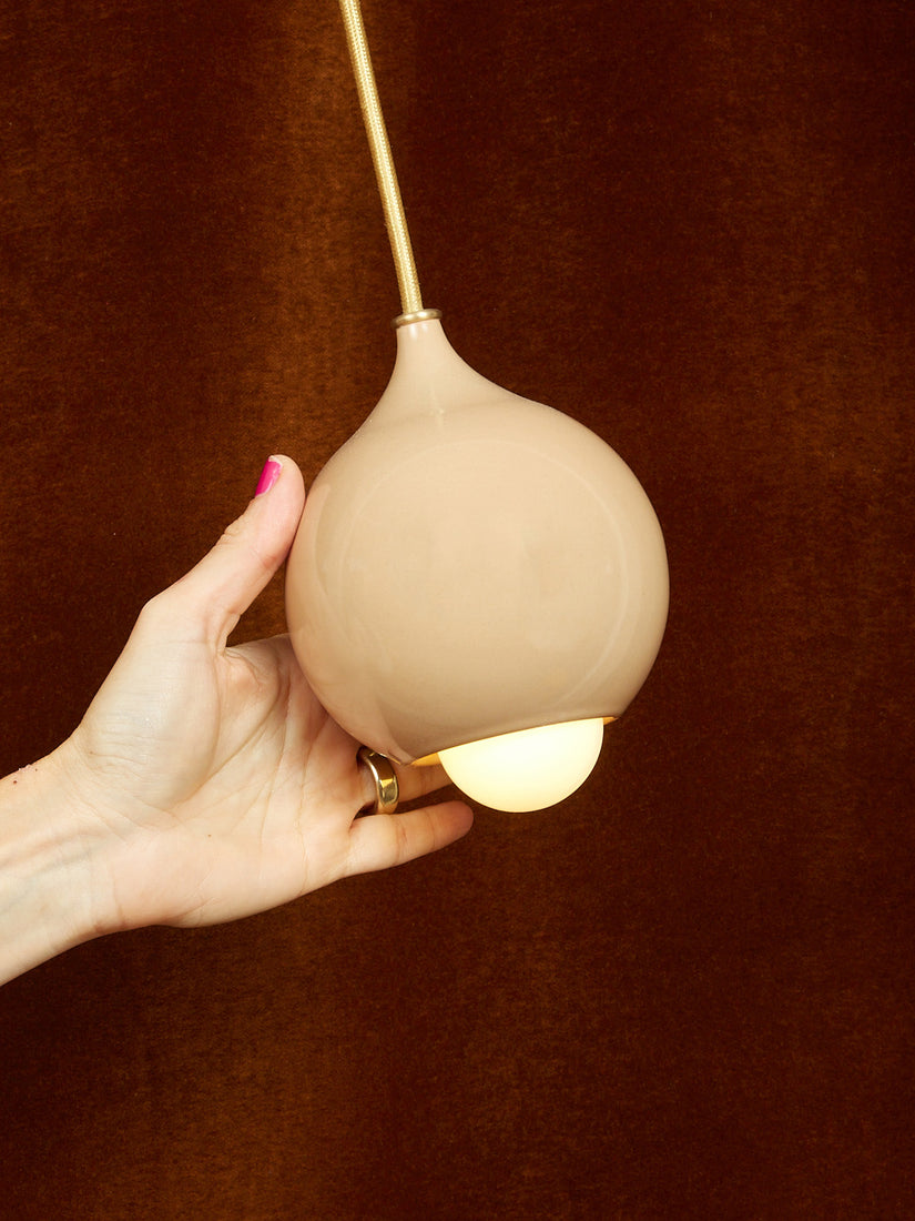 A hand holding a Droplet pendant by Entler.