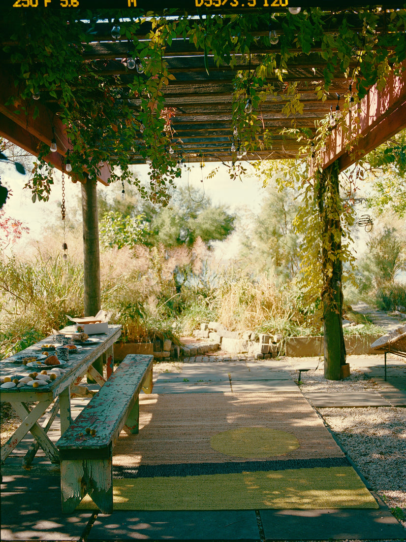 The Changeling Rug by Cold Picnic in an outdoor garden under a lush gazebo.
