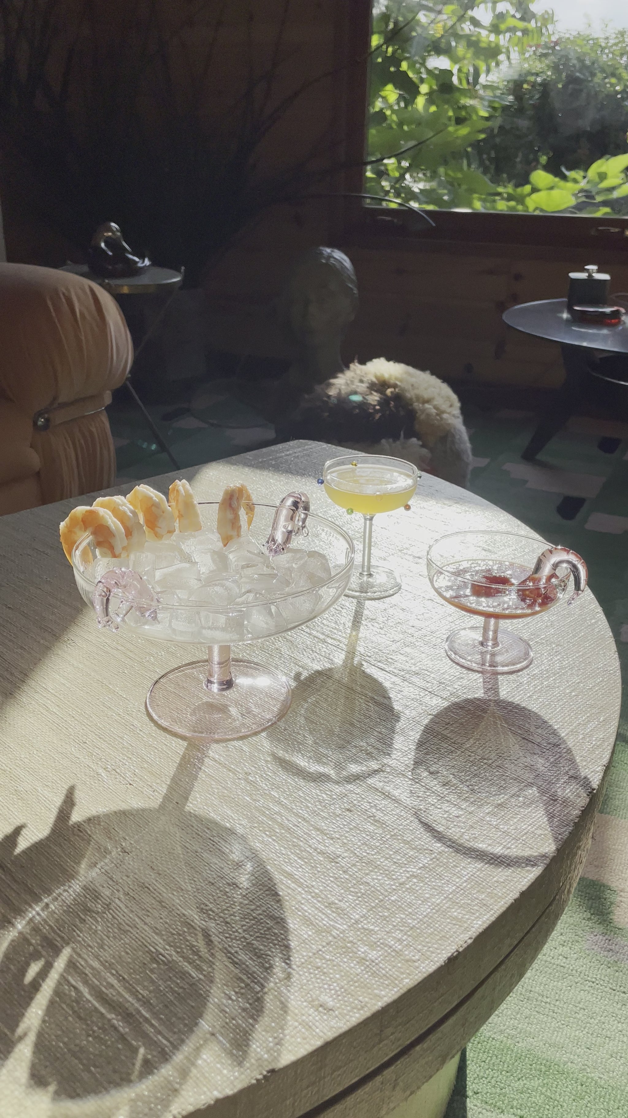 Someone enjoying a shrimp from the Maison Balzac Shrimp Cocktail platter and coupe.