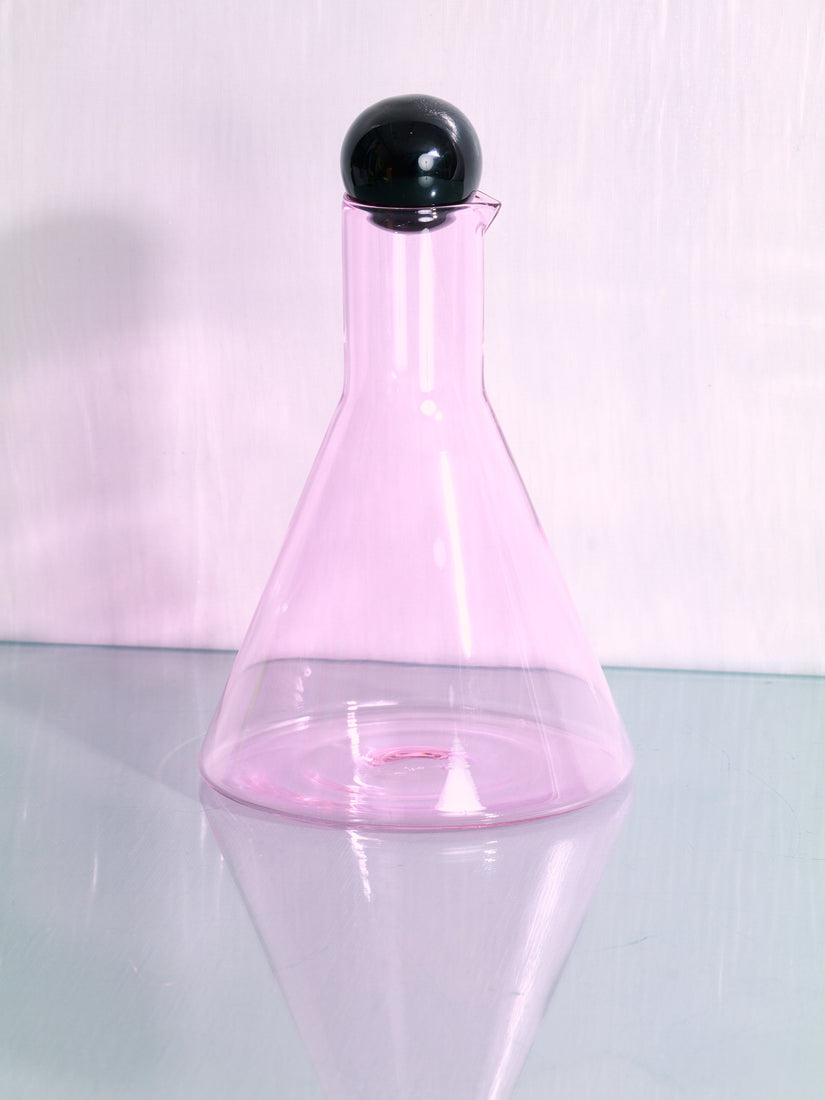 Bilboquet Carafe by Sophie Lou Jacobsen featuring a beaker shaped pink form and black sphere stopper.