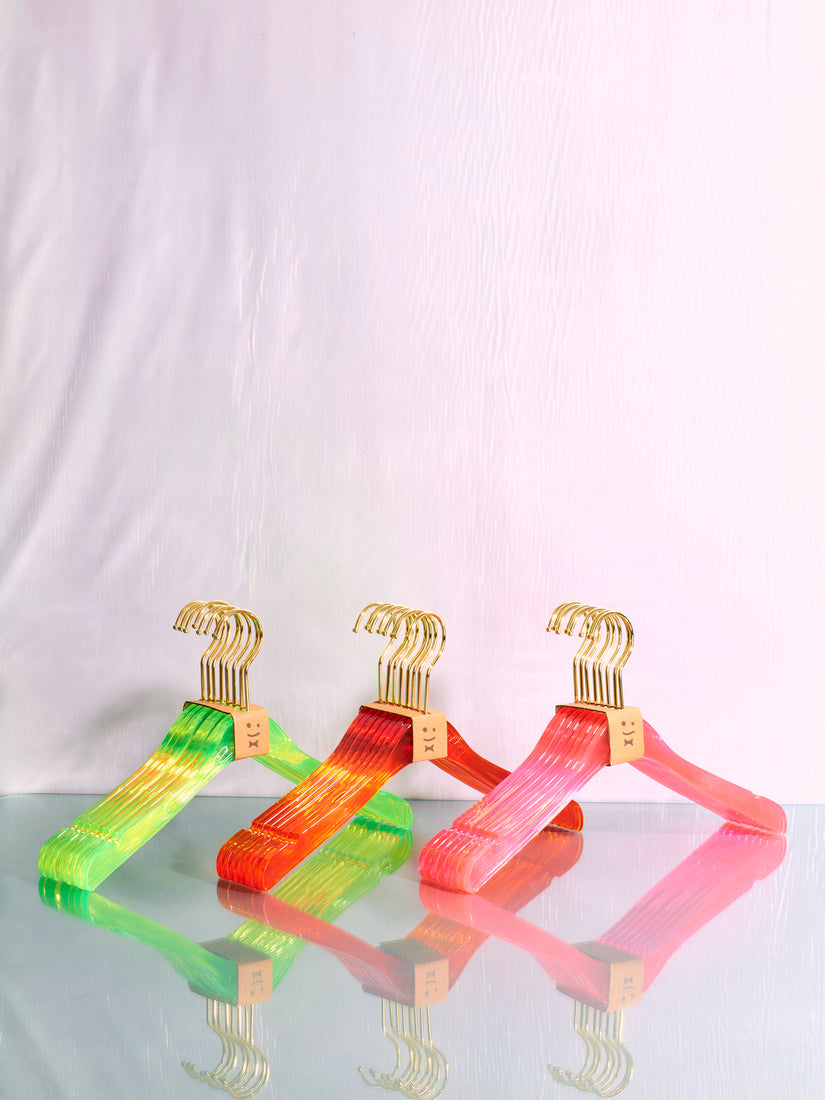 Pink, orange, and green sets of hangers by Staff.
