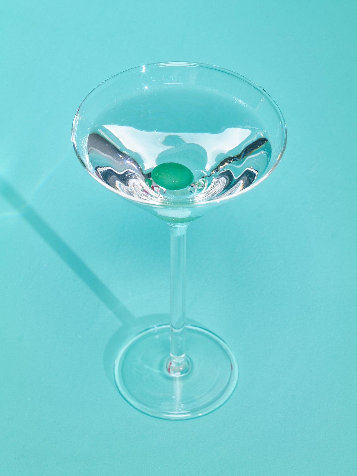 Martini Glass by Maison Balzac full of a clear liquid.