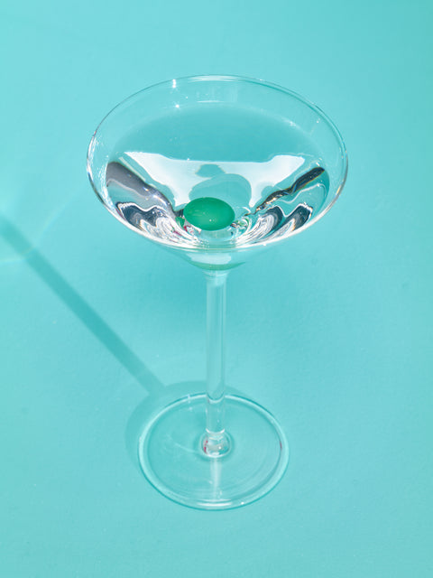 Martini Glass by Maison Balzac full of a clear liquid.