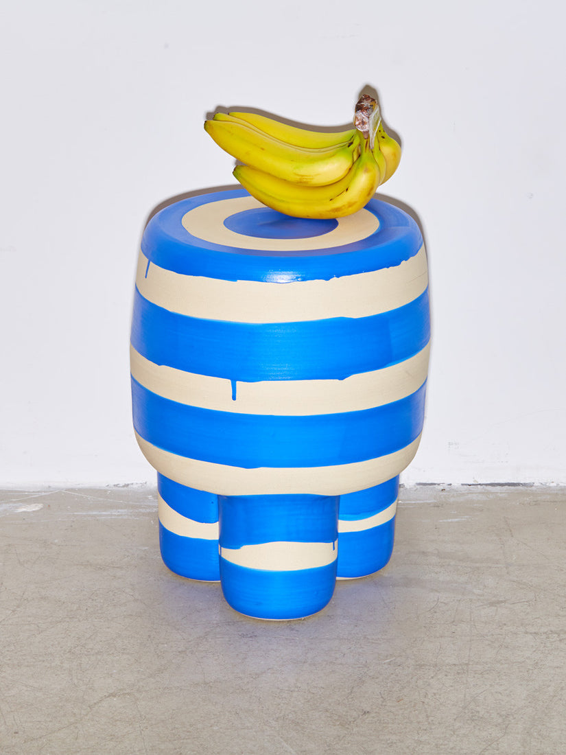 A bunch of bananas sits atop a blue Ceramic Milking Stool by Workaday Handmade.