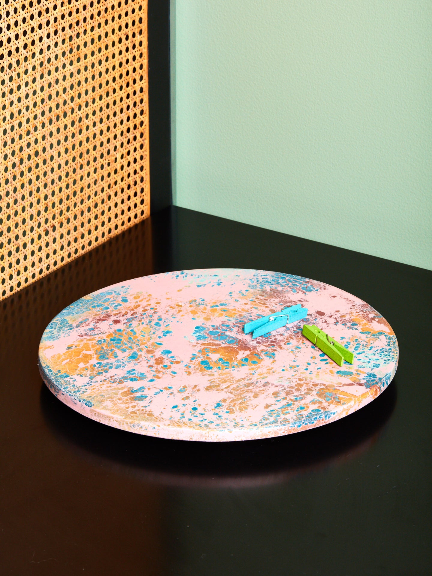 A green and blue clothespin sit atop a Jerry Berry Lazy Susan by Concrete Cat.