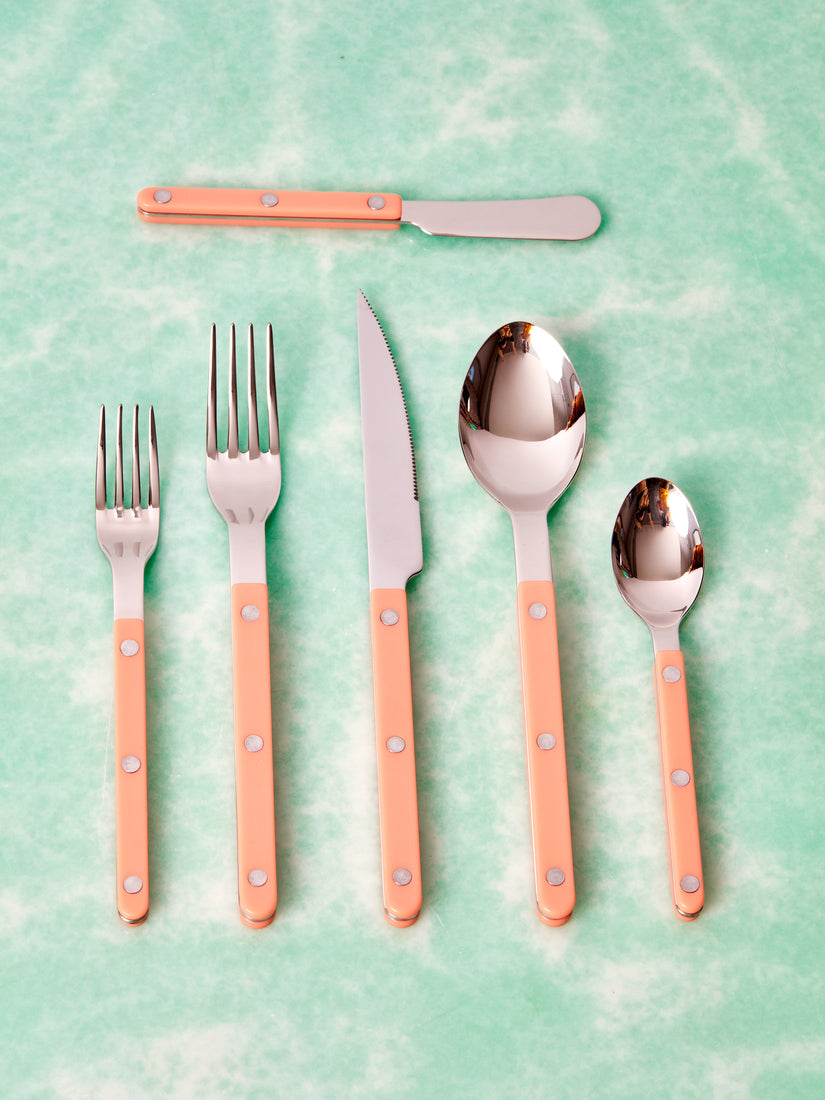 Six different pieces of pastel coral flatware by Sabre.