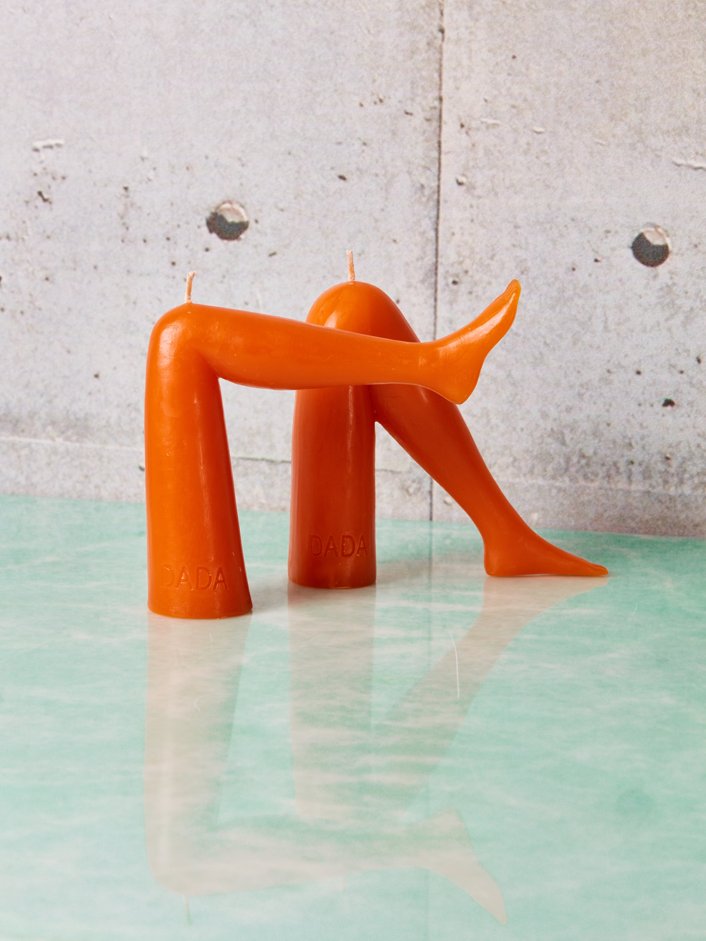 A pair of orange leg candles by Dada.