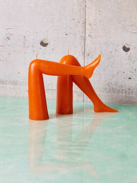 A pair of orange leg candles by Dada.