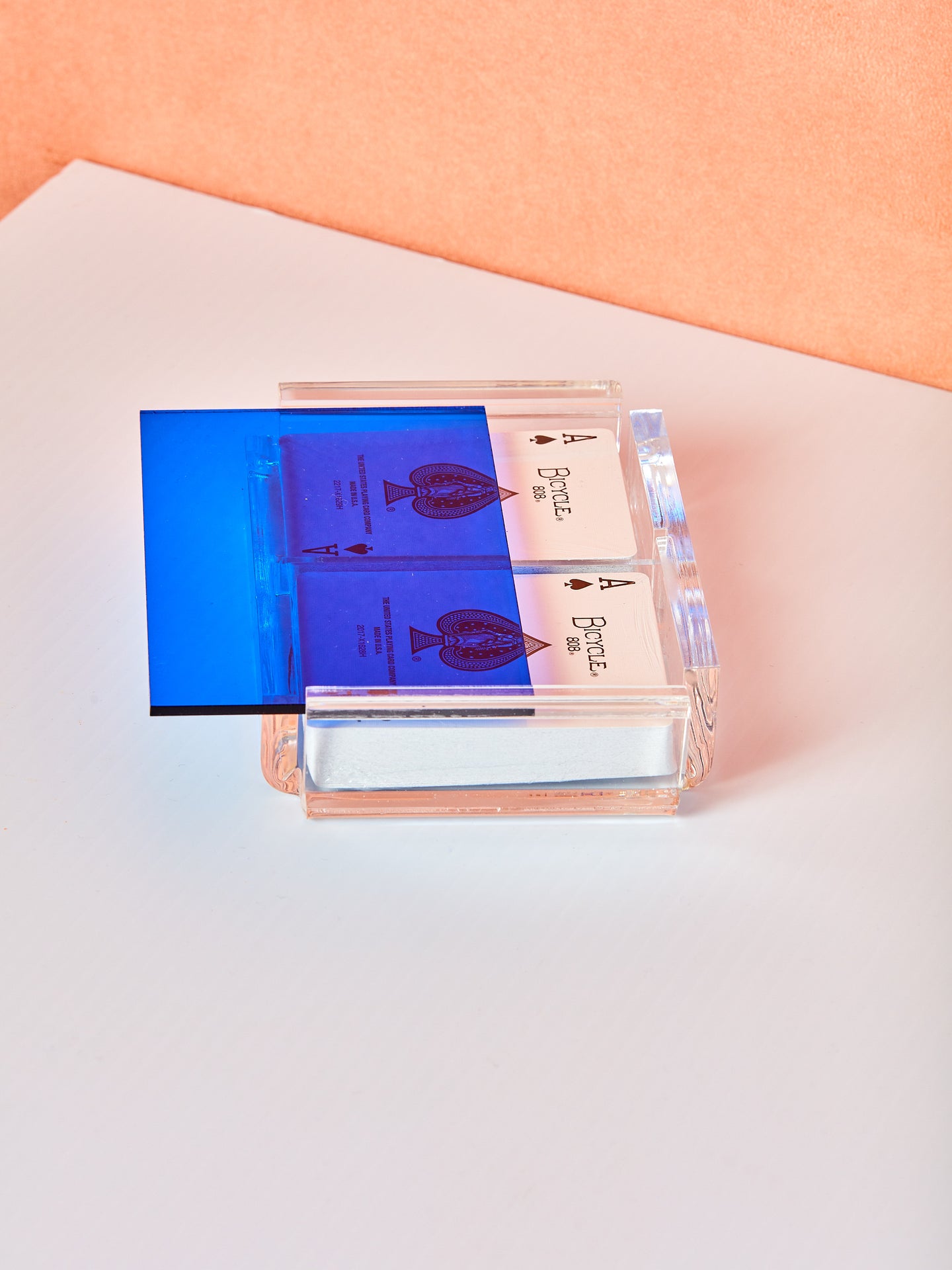 Blue Set of Luxe Playing Card by Luxe Dominoes. An acrylic case with a colored transparent acrylic lid and two decks of bicycle playing cards inside.