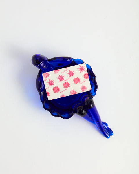 A pink floral printed gift card sits inside a cobalt blue bathing lady dish.