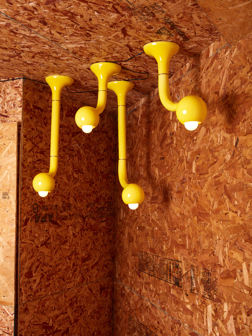 Four yellow ceramic ceiling lamps by Entler Studio hanging in a completely plywood room.