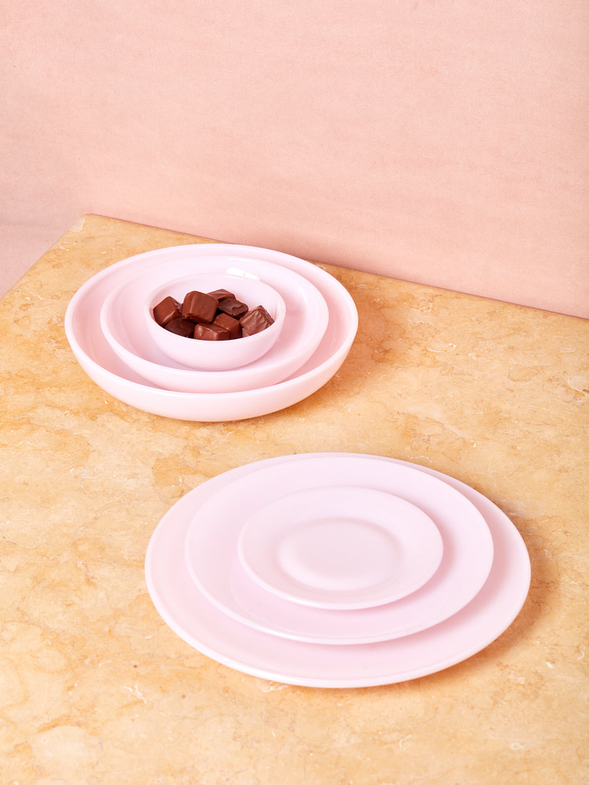 Pink Milk Glass Dinnerware by Mosser bowls and plates stacked by shape.