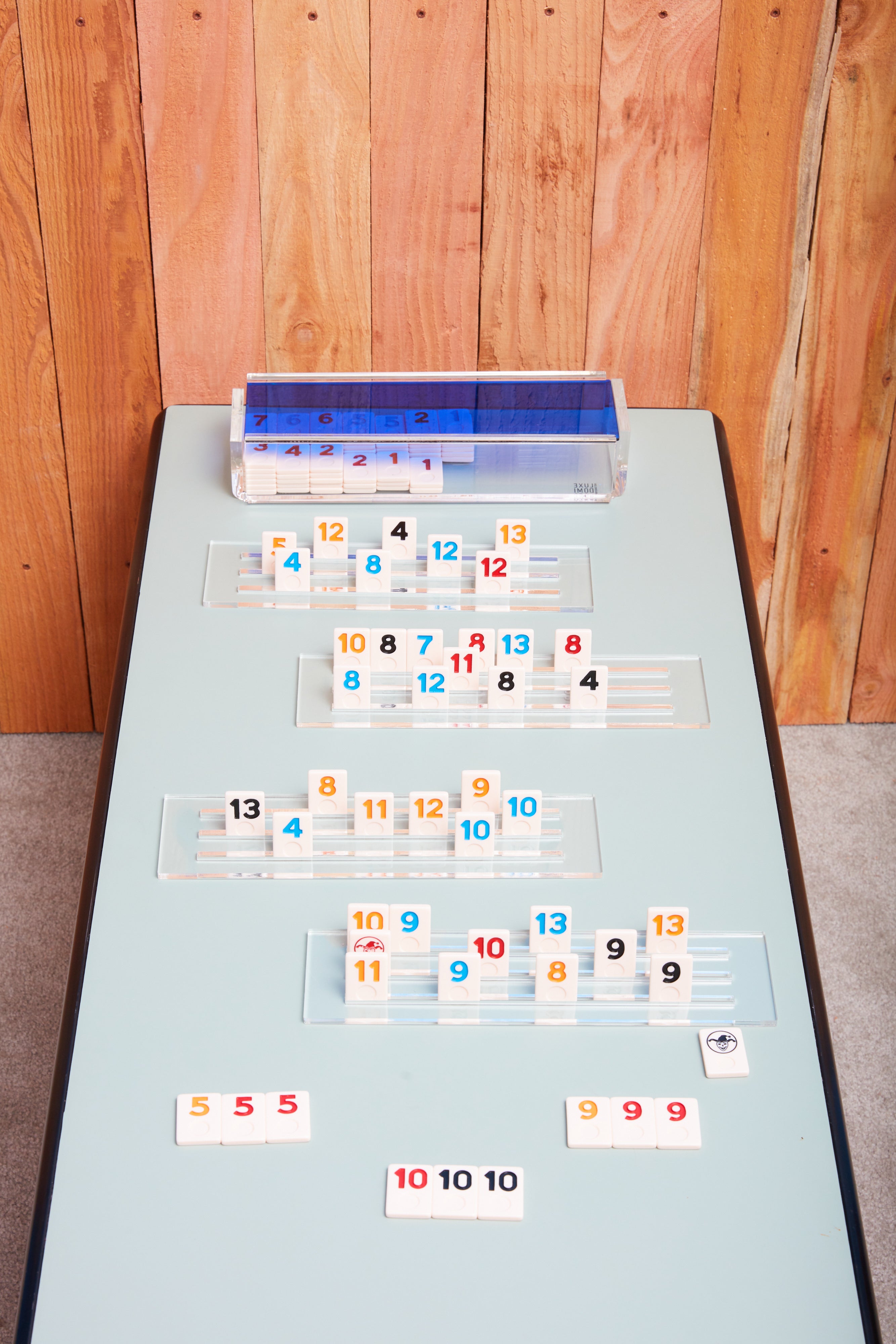 A blue rummy game by Luxe Dominoes in play.