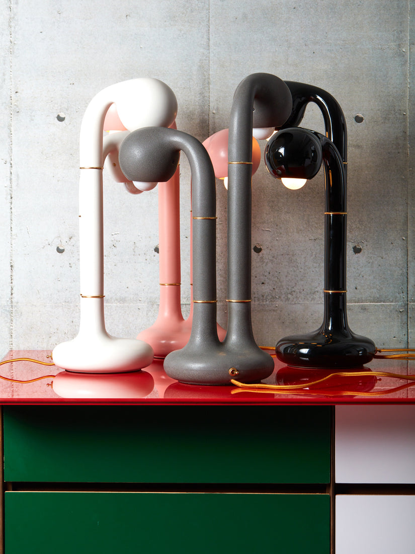 Four Entler two globe table lamps sit closely intertwined.