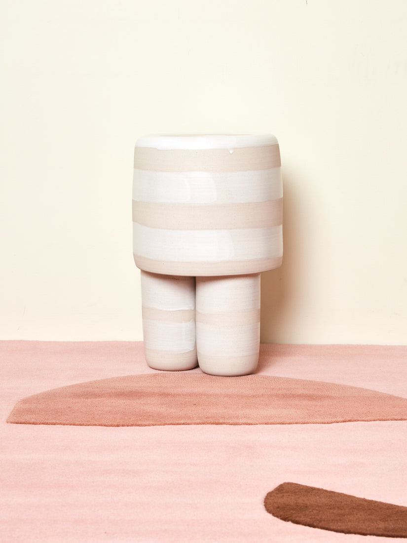 Ceramic Milking Stool by Workaday Handmade in white stripes sitting on a pink Cold Picnic rug.