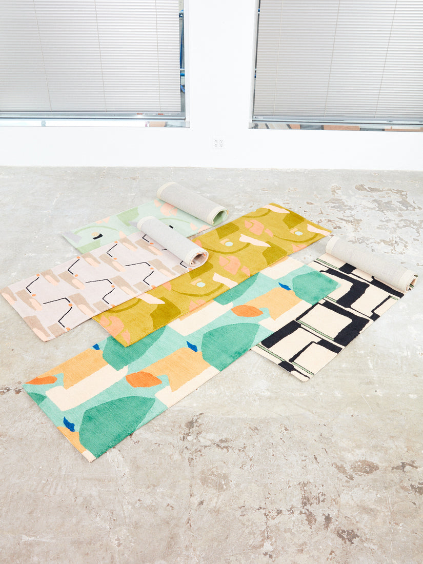 5 Motif Runner Rugs by Cold Picnic rolled out in different amounts and scatter stacked on top of each other.