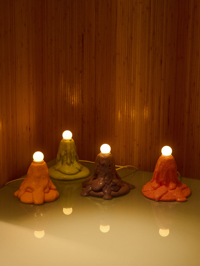 Four Baby Foam Lamps in different colors glowing in a dark room.