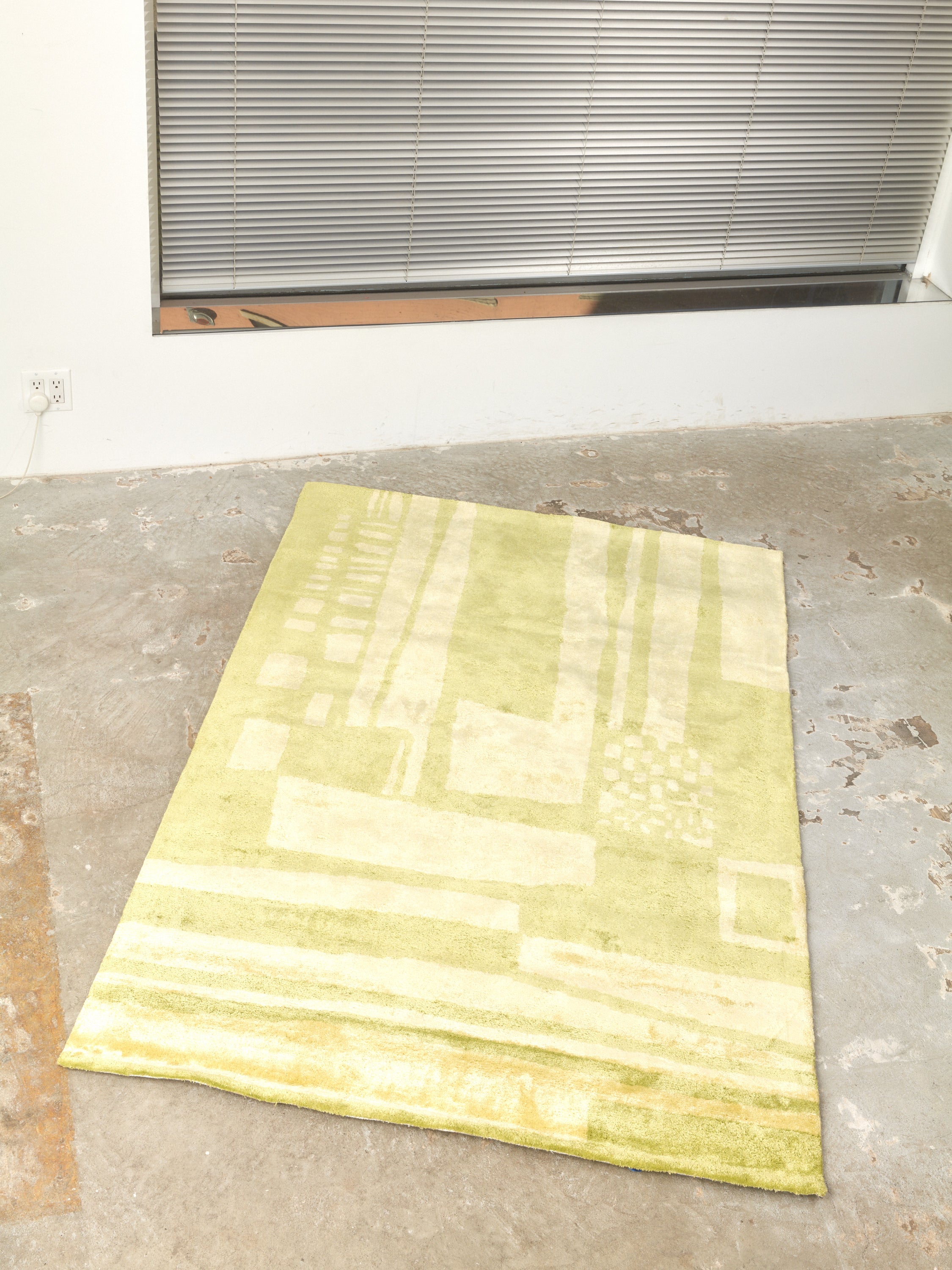 4x6 Battenberg in Matcha (lime and chartreuse) Rug by Cold Picnic. Rug is displayed on concrete floor.