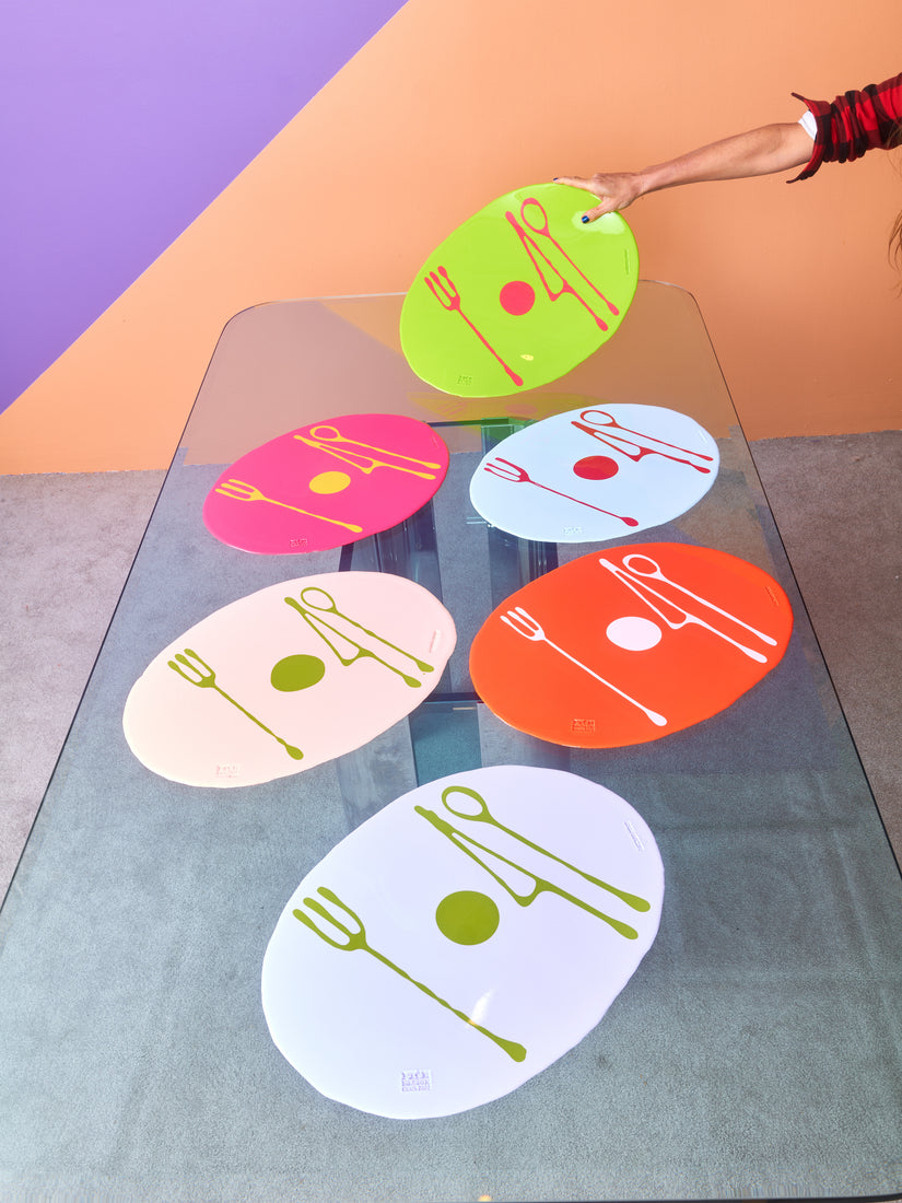 A glass dining table with six opaque Table Mates Placemats in different colors by Gaetano Pesce for Fish Design.