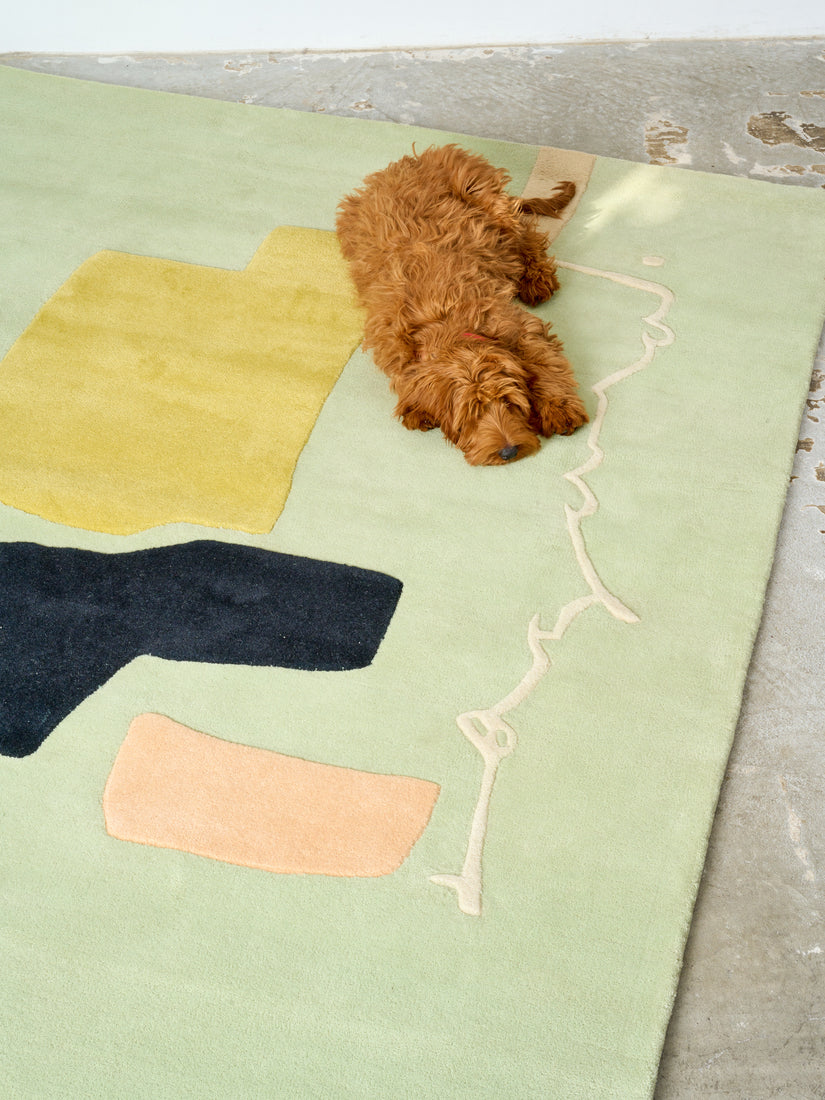 A brown dog lays on the Bodies of Water High Tide Rug by Cold Picnic.